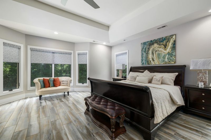 Sophisticated modern bedroom featuring luxurious furniture, large windows, and stylish decor with ample natural light