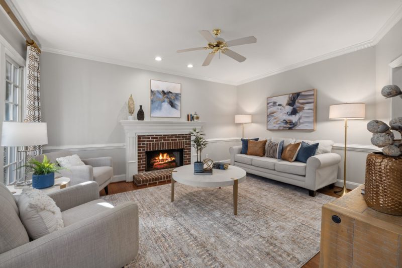 A cozy modern living room featuring a fireplace, elegant sofa, and tasteful decor